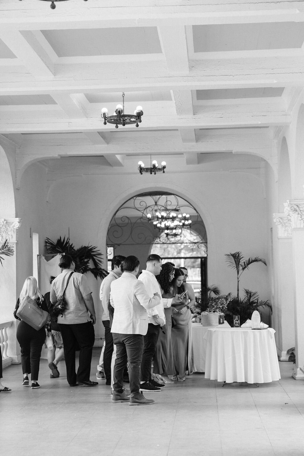 Guests arriving at welcome table in black and white surrounded by european architecture