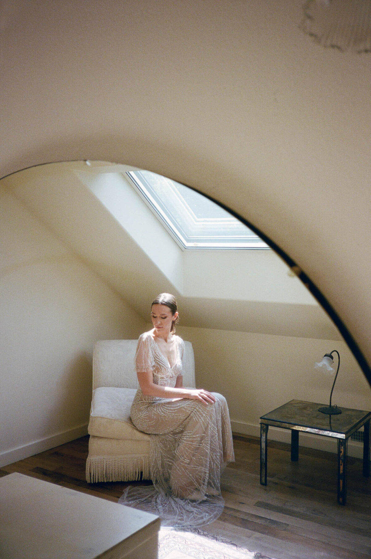 Bride sitting in chair in the bridal suite at The Griffin House wearing Dana Harel.