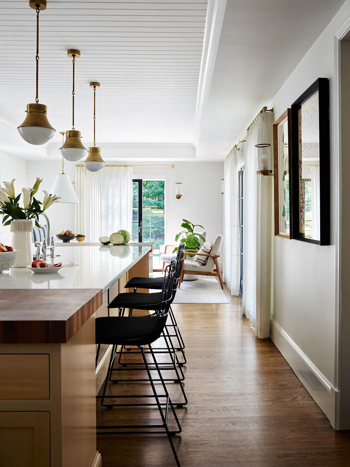 View the kitchen in a historic Hingham home, showcasing new sliding doors leading to the pool deck and outdoor dining area, enhancing the connection to outdoor living spaces.