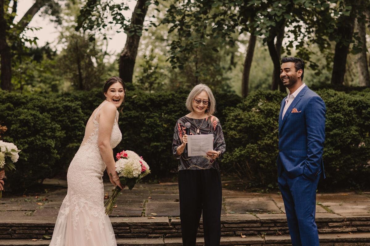 A wedding couple laughing during their wedding ceremony 