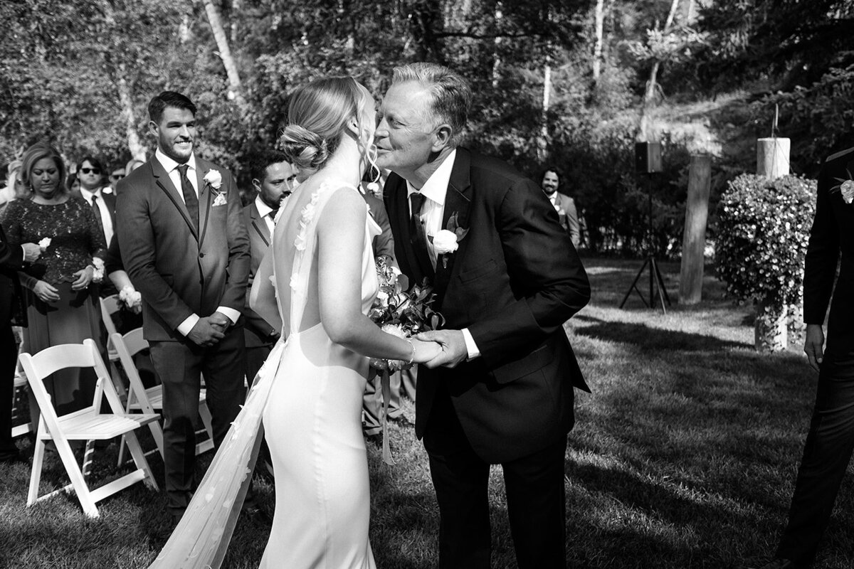 bride kisses her dad after he walks her to the end of the aisle