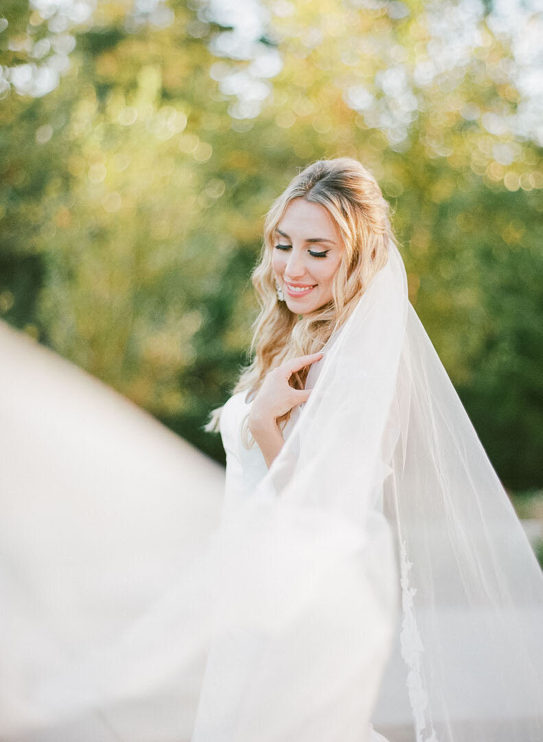 Bride Looking Over Shoulder with Veil Sweeping In Front Photo