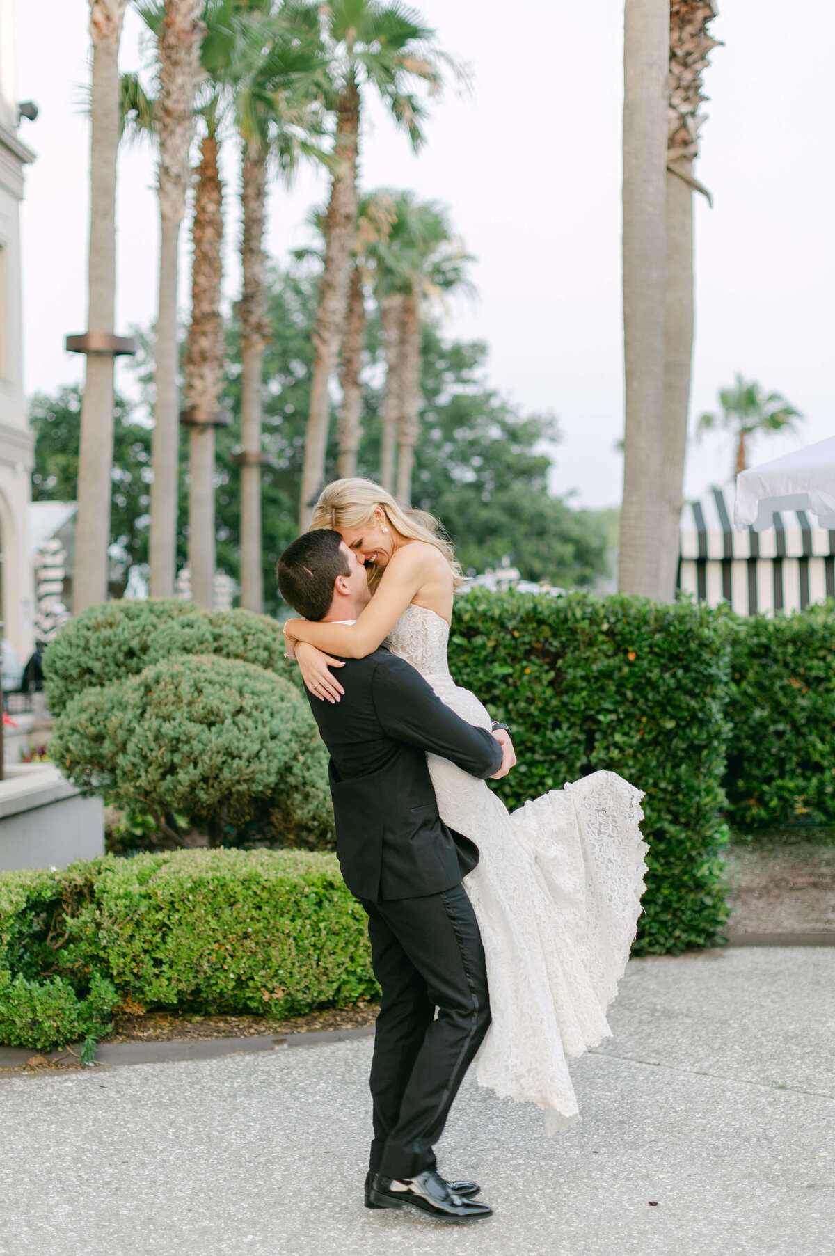 A groom hold his bride above him.