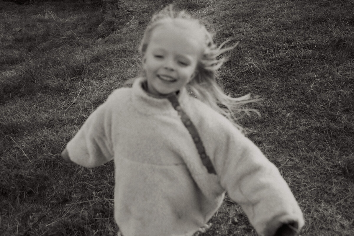 Perhekuva 4-vuotiaasta tytöstä juoksemassa nauraen Suomenlinnassa.