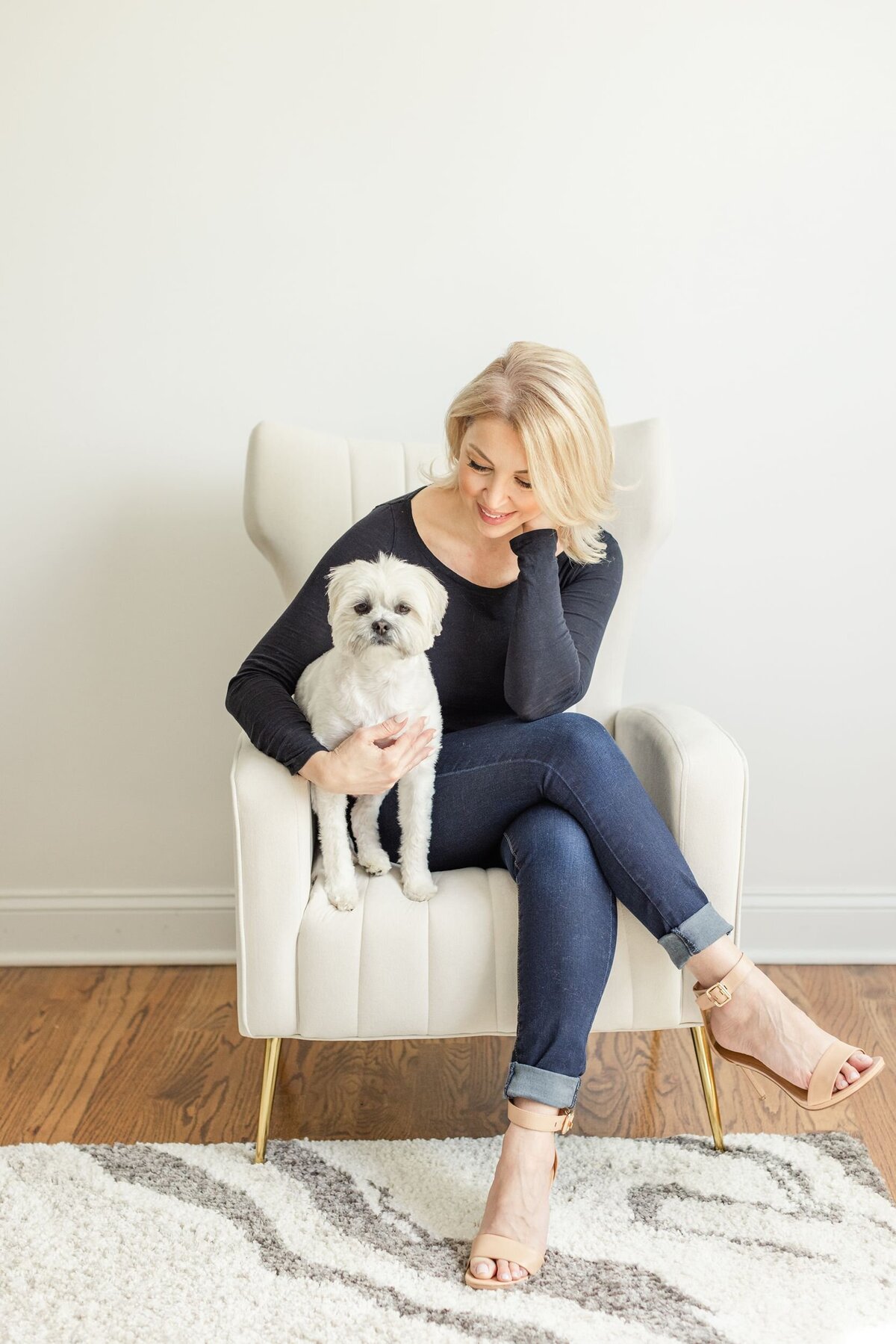 Woman sitting on chair with white dog