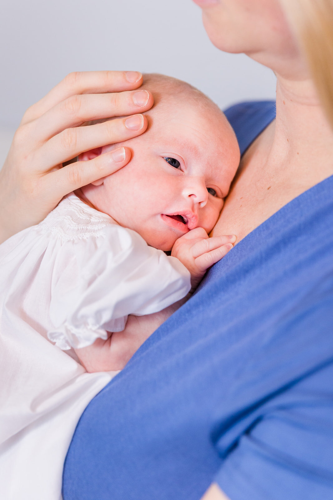 newborn baby resting on mom chest mom wearing blue dress Laure Photography Atlanta family and newborn photographer