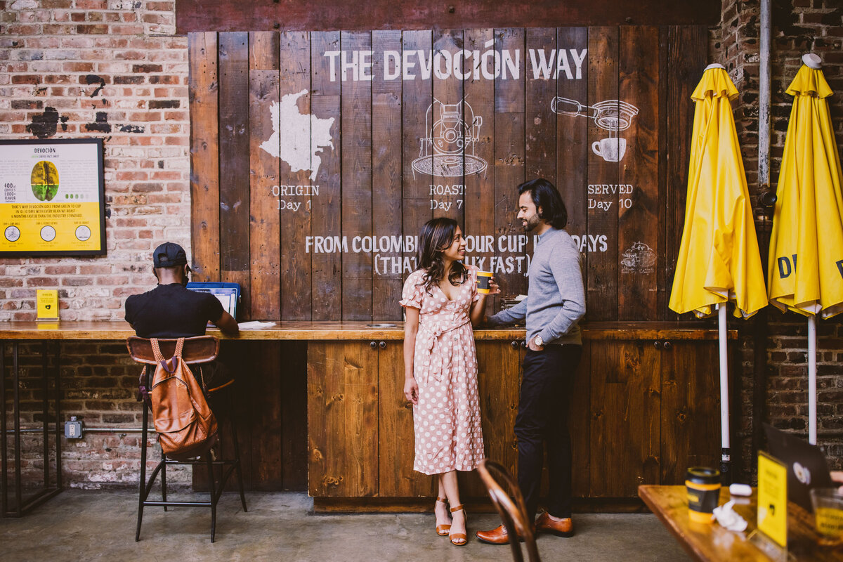 A couple having coffee together standing inside devocion in brooklyn