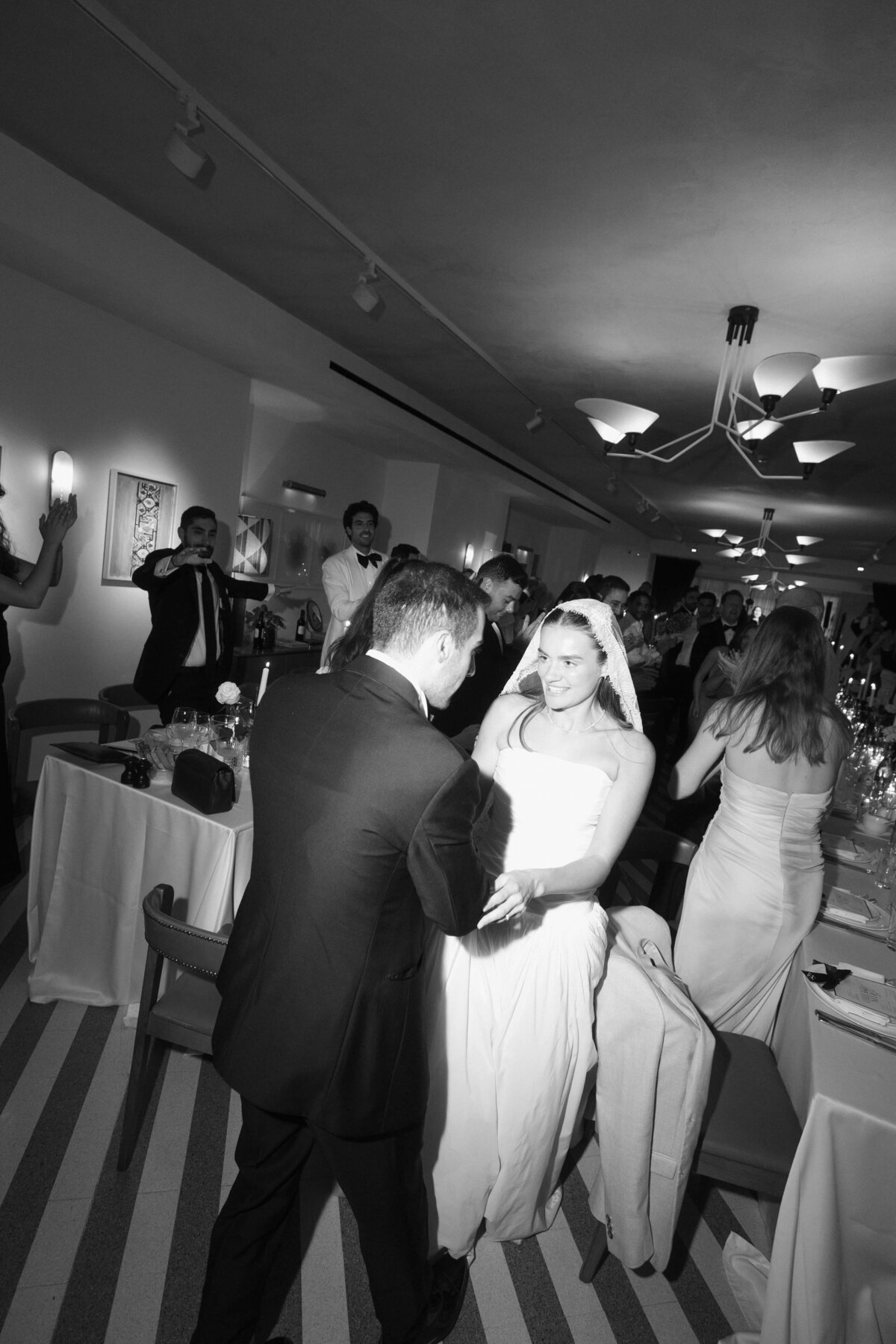 Bride dancing with arms raised during joyful wedding reception moment

