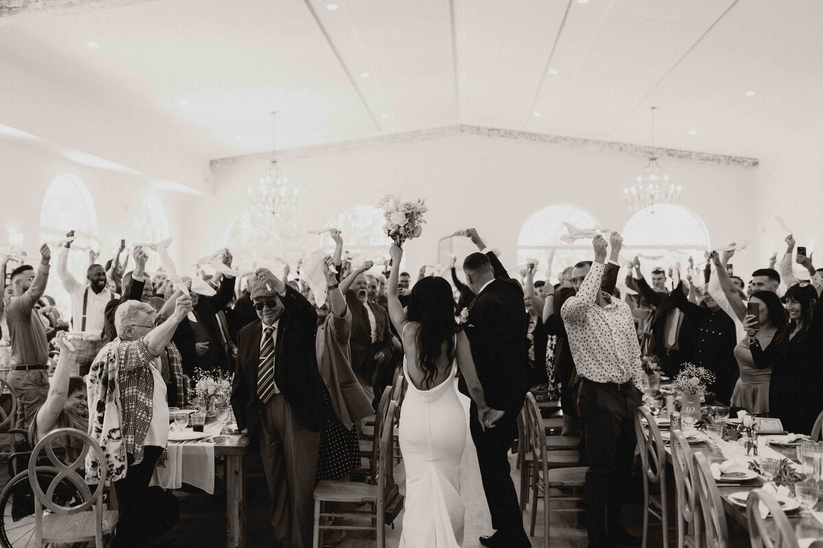 Candid moment of a couple entering their Alberta wedding venue post-ceremony