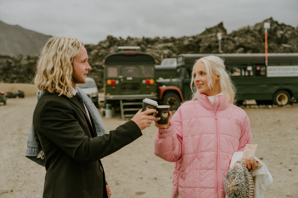 couple warming up to hot chocolate while eloping in the iceland's highlands