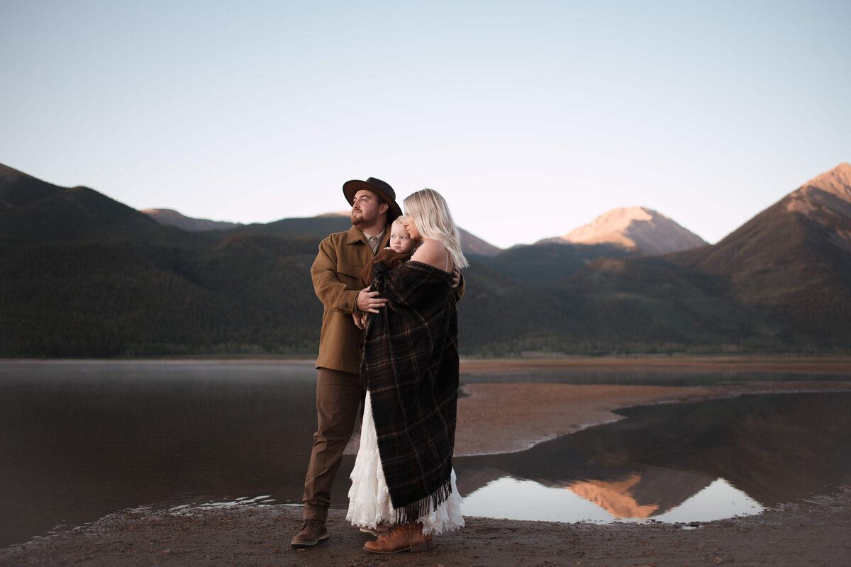 An intimate family moment—two parents wrapped in love, holding their son close.