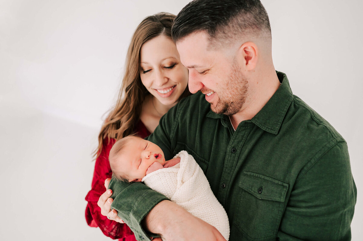 Springfield Mo newborn photographer captures parenting looking down at sleeping newborn son