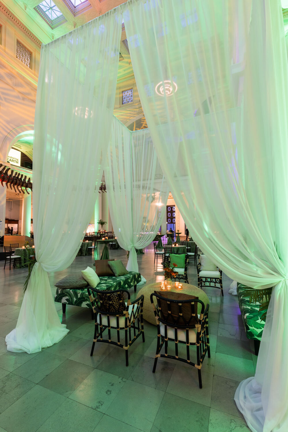 Lounge area with palm print seating and flowing white drapes