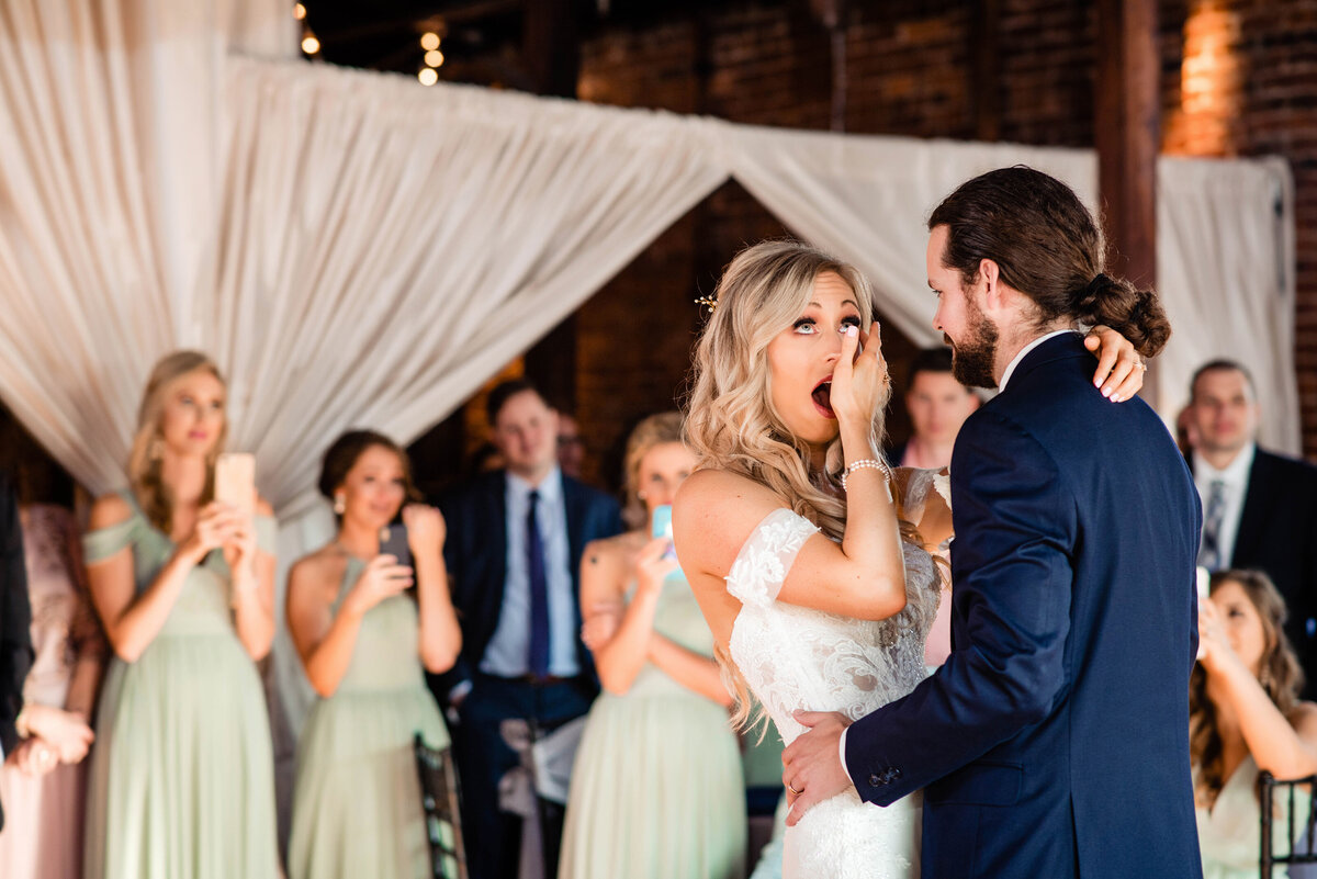 Bride wiping tears away during her first dance with her husband
