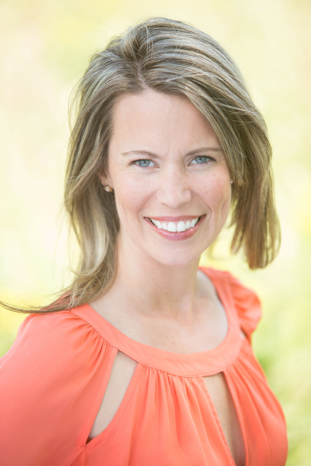 Woman smiling in an orange dress outdoors