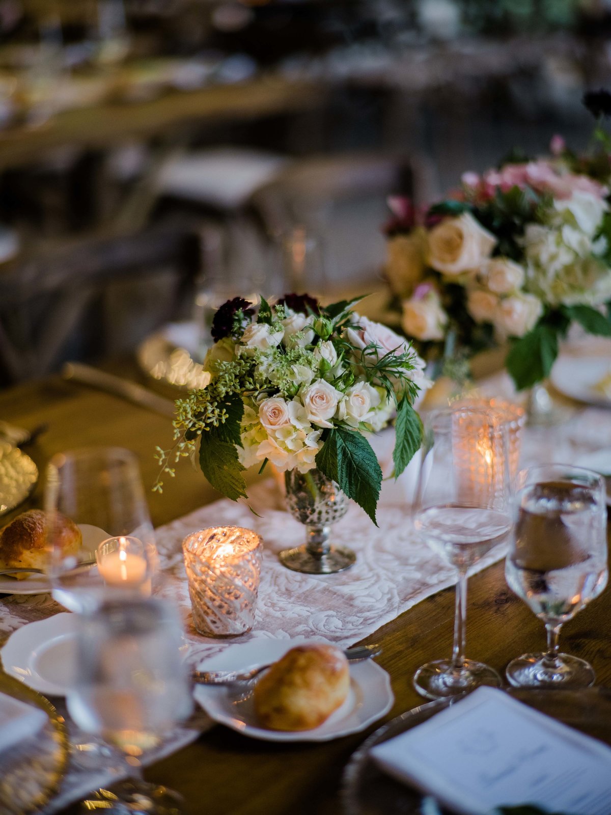 Long wooden tables with a runner and small floral compotes are perfect for a late summer garden wedding.