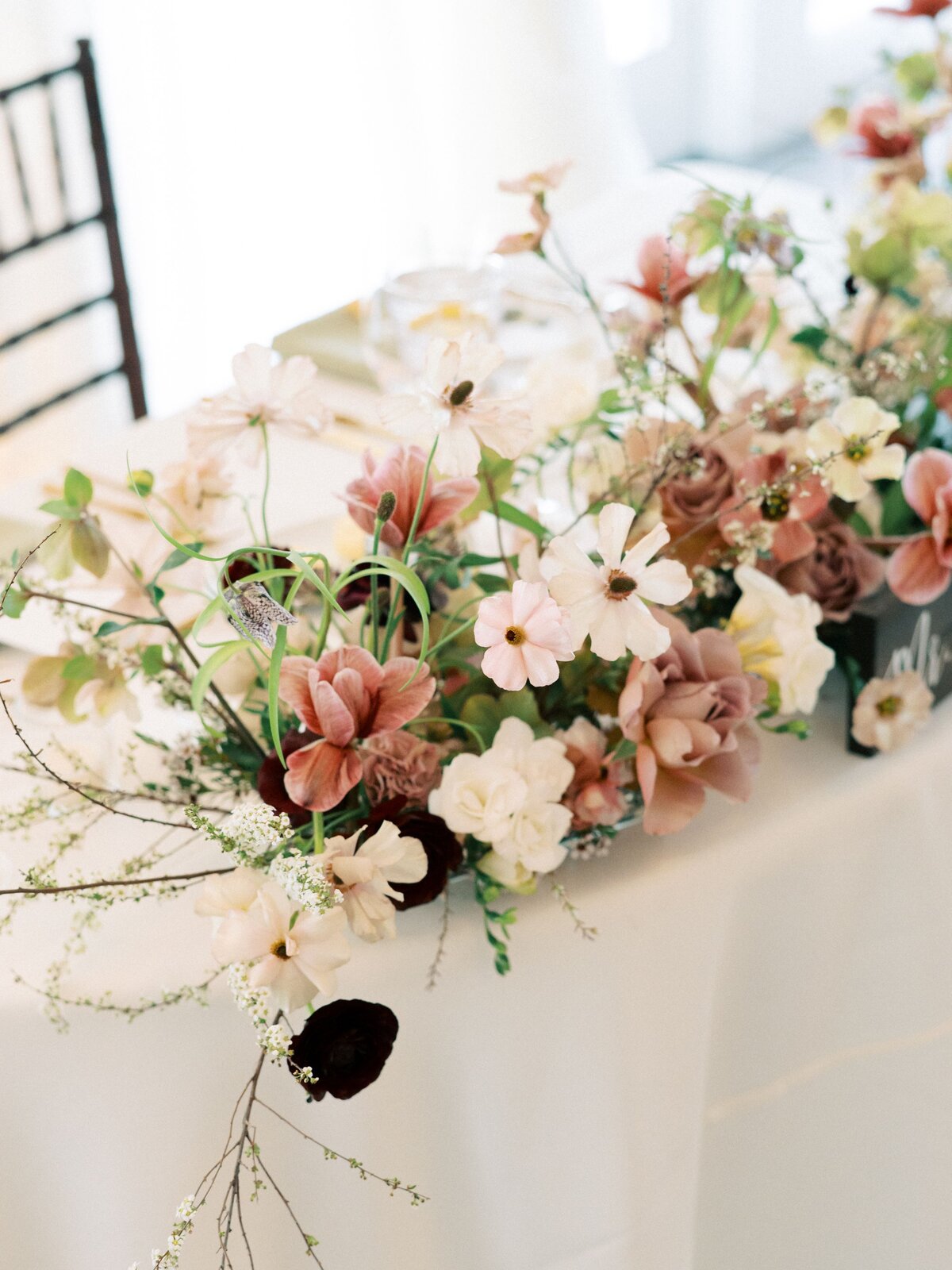 unique floral design for sweetheart table flowers with butterfly ranunculus, tulips, hellebore and frittilaria