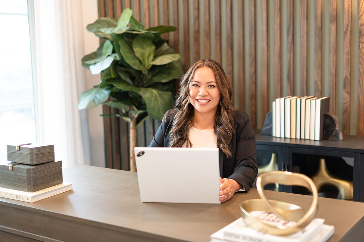 Smiling businesswoman at laptop during Houston personal branding photoshoot session