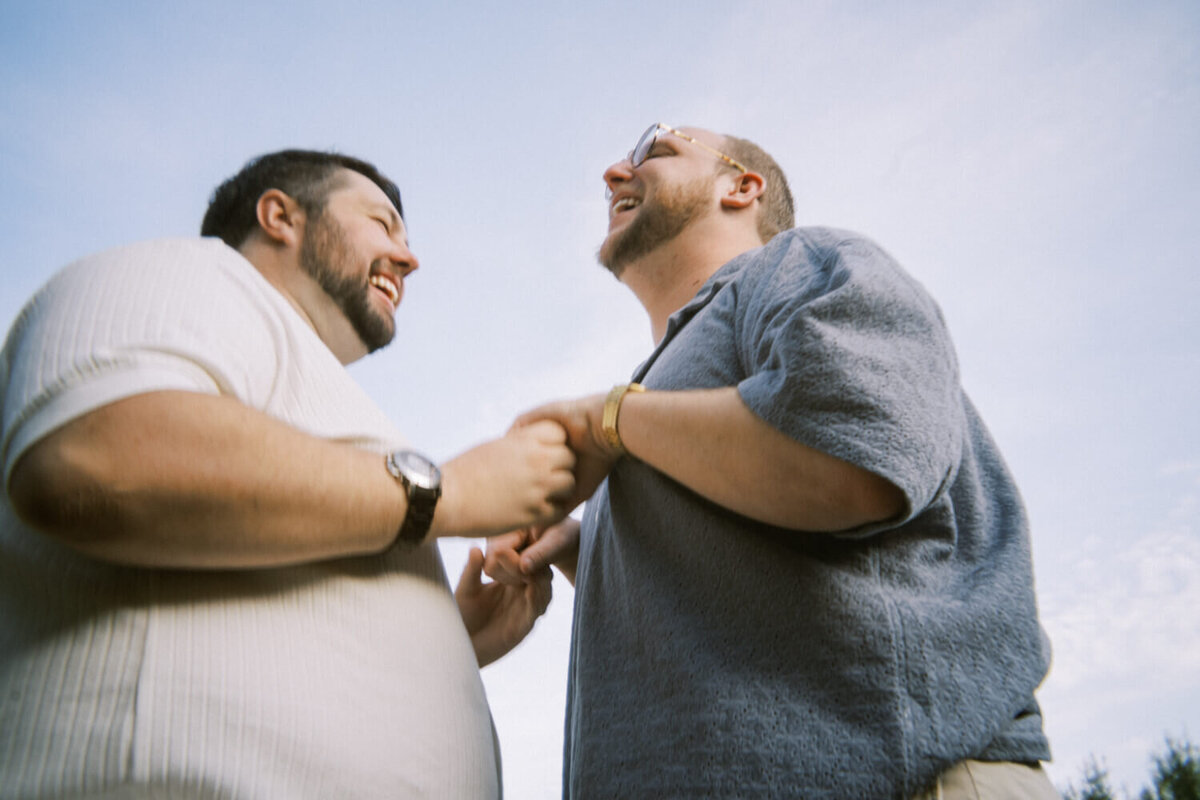 men-holding-hands-and-laughing