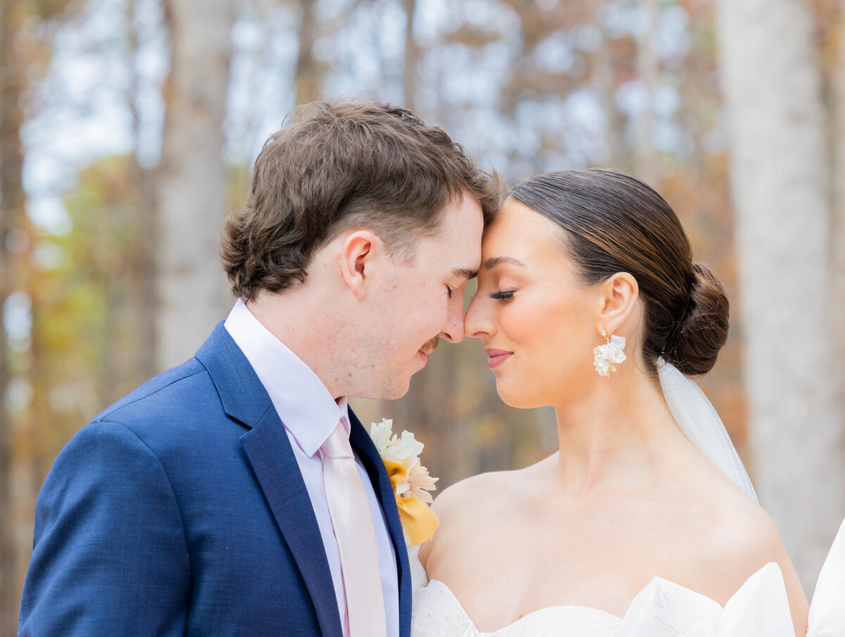 bride and groom touching foreheads during wedding portraits