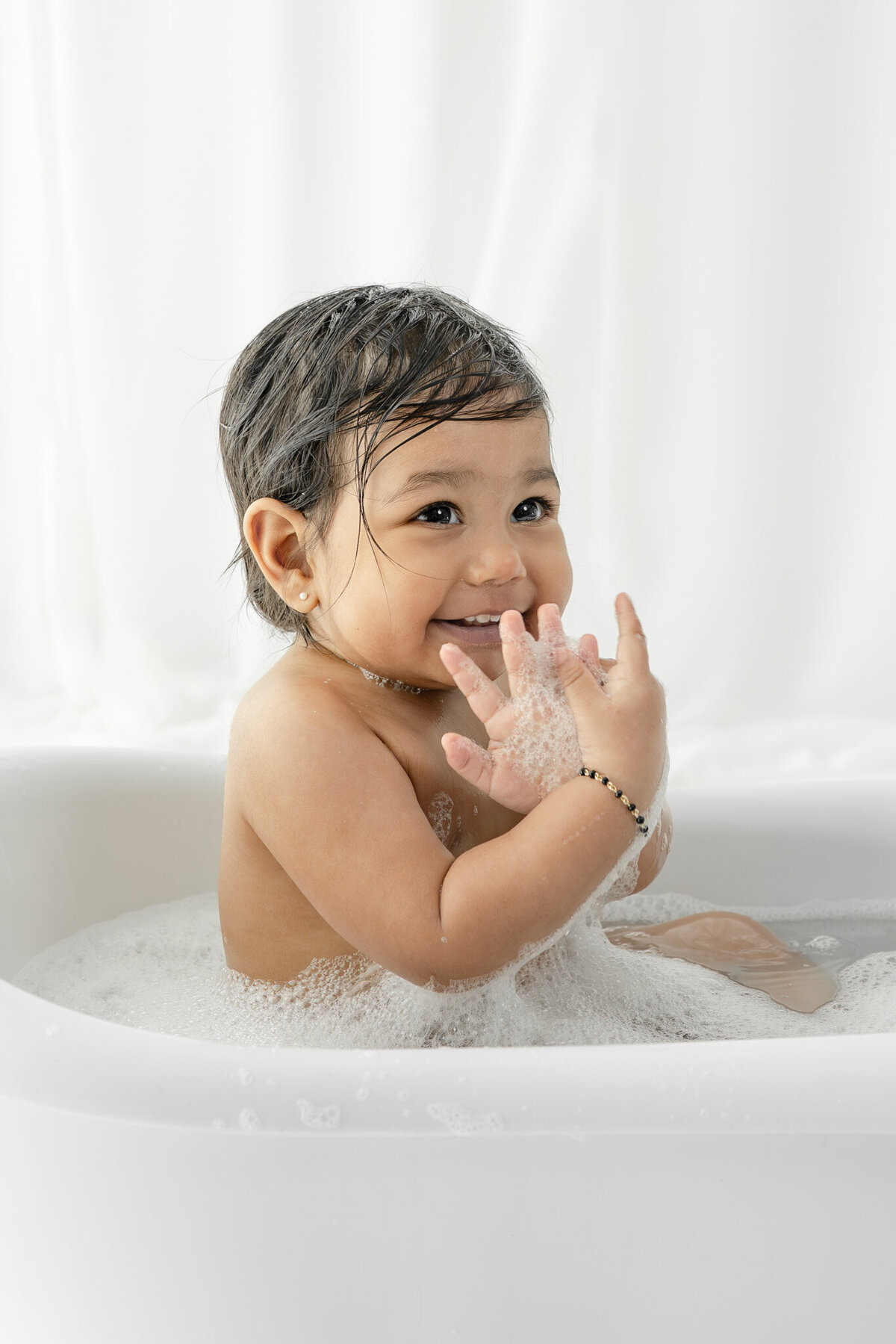 Girl in bubblebath following cake smash session— captured by Alliston and Barrie cake smash photographer.