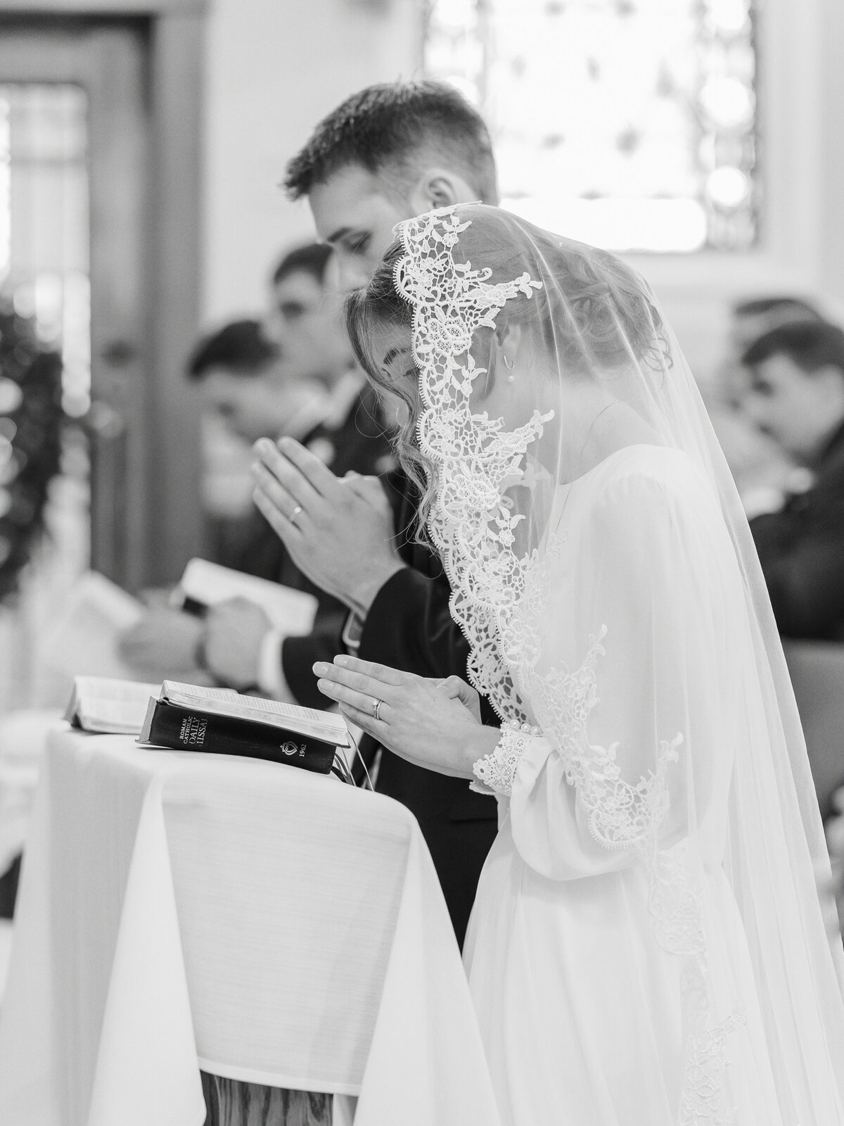 Couple praying at altar during Catholic wedding at our Lady Of Victory in Rochester