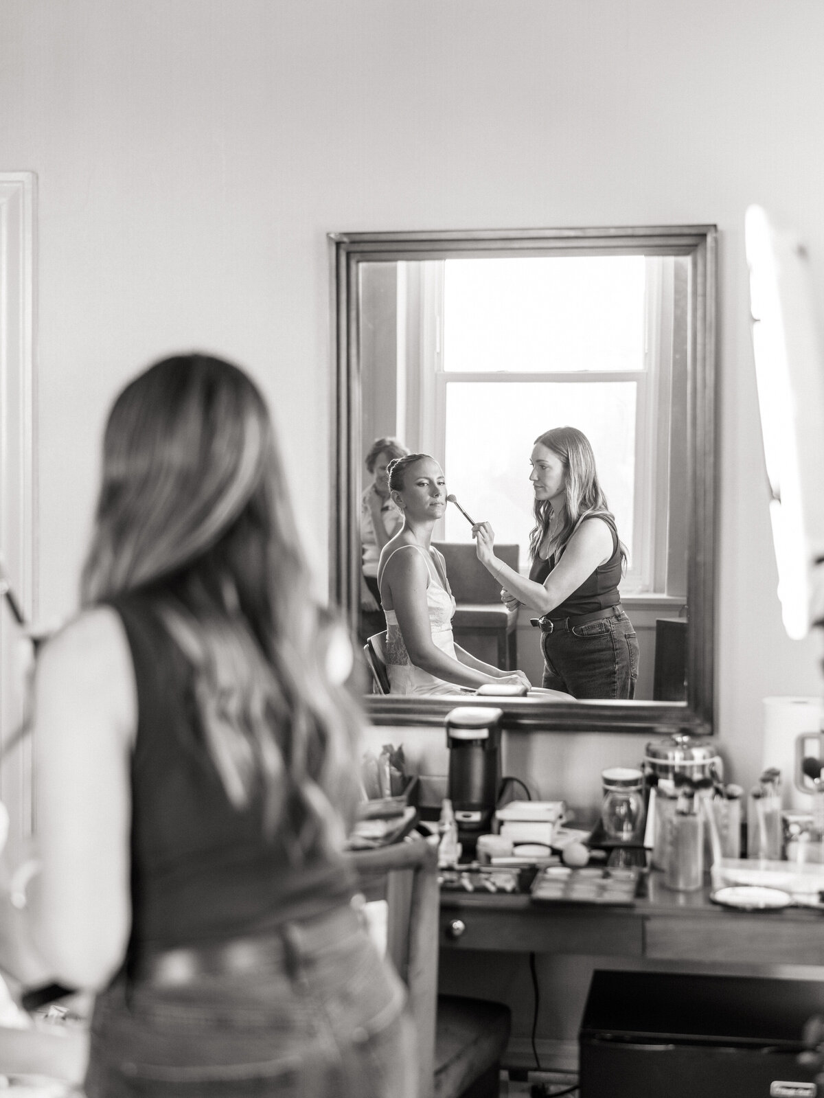 Bride getting makeup done before Philly wedding ceremony, captured by Philadelphia wedding photographer.