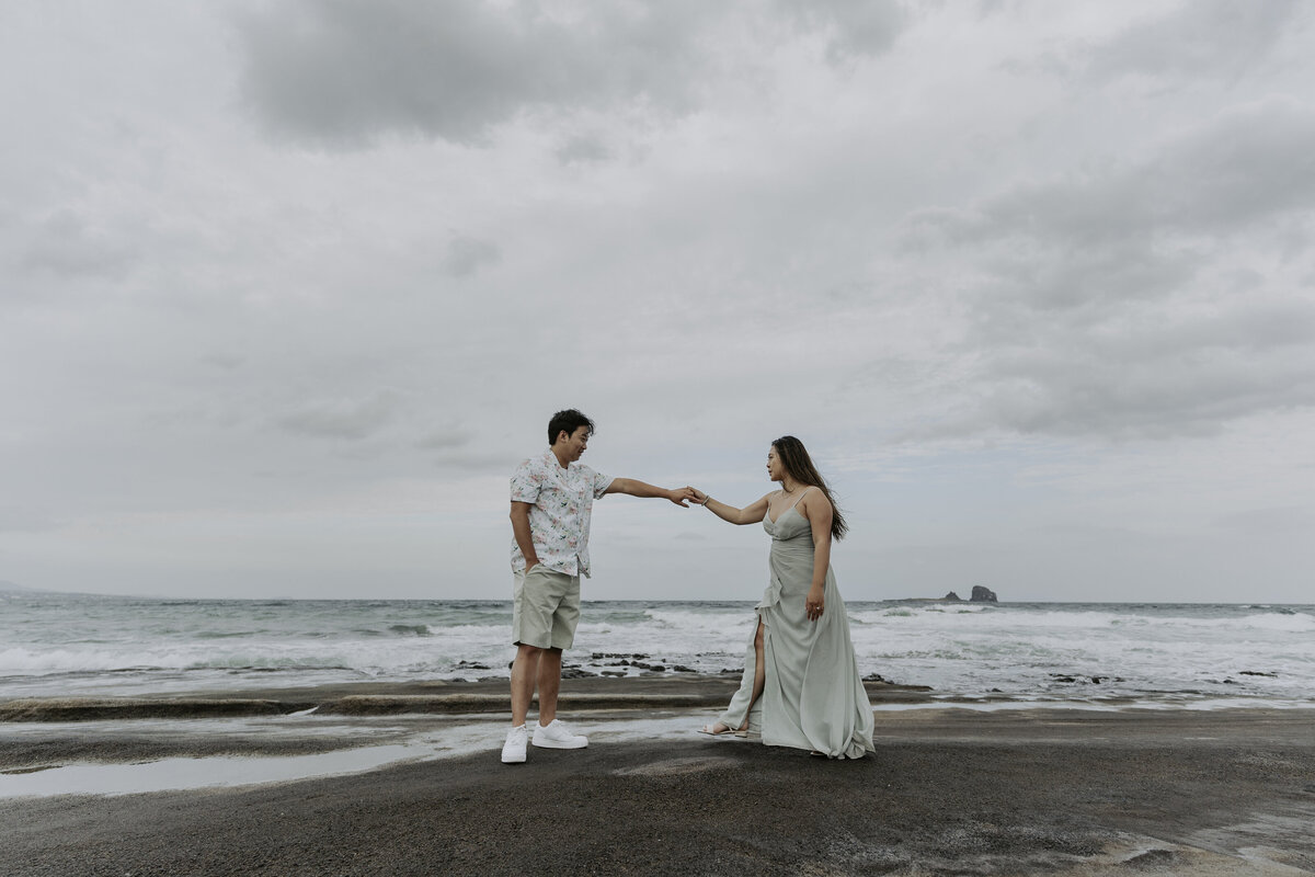 the couple held out their hands together at the shore of Gwangchigi Beach in jeju island