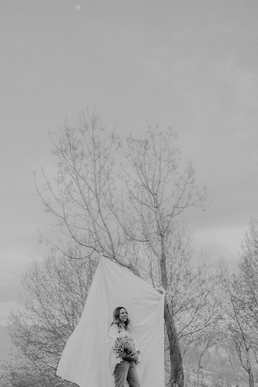 A woman stands in front of a sheet