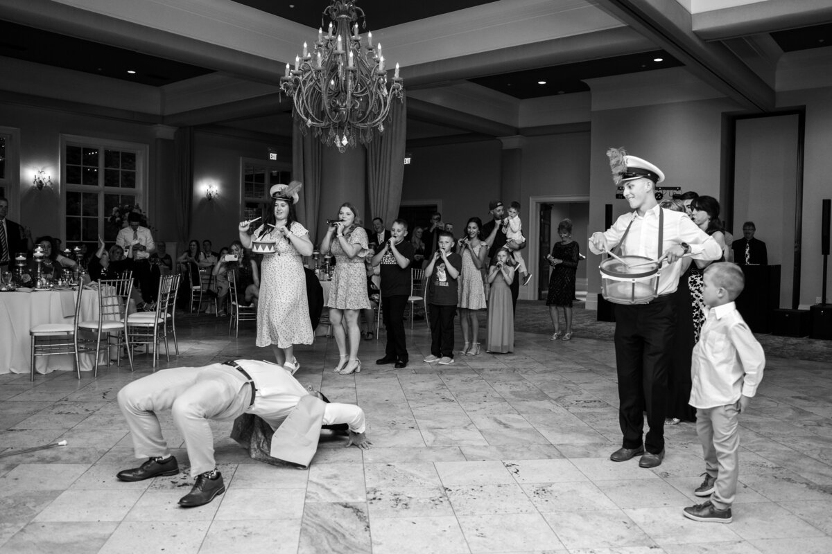 Drum major does a back bend on the dance floor with a drum line  on both sides at a wedding at Pinnacle Golf Course in Grove City, Ohio.