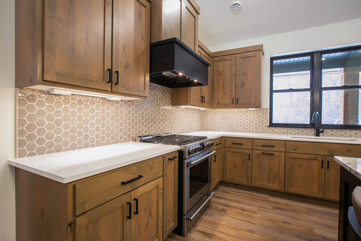Open kitchen with dark cabinets, large island, and quartz countertops in an Elk River custom home