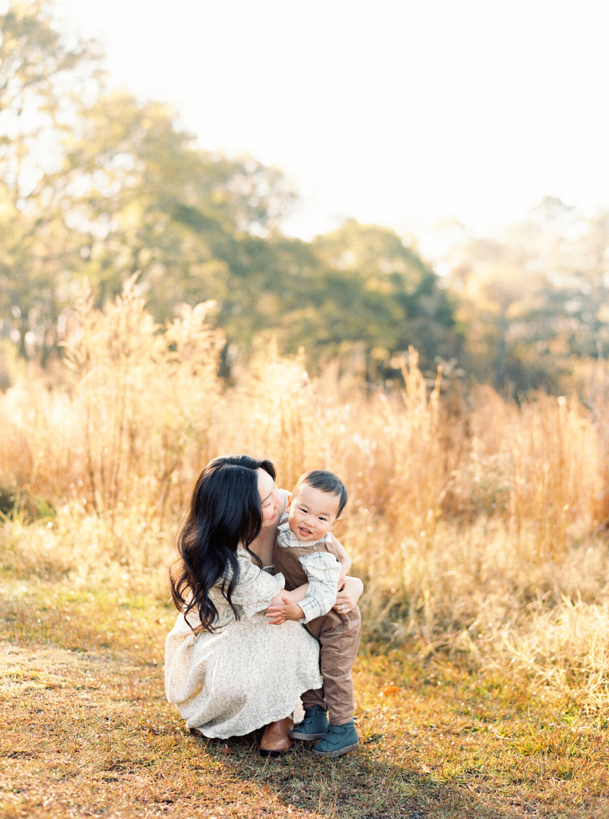 Mom squats down to her son's level to play with him. Image by Raleigh maternity photographer A.J. Dunlap Photography.