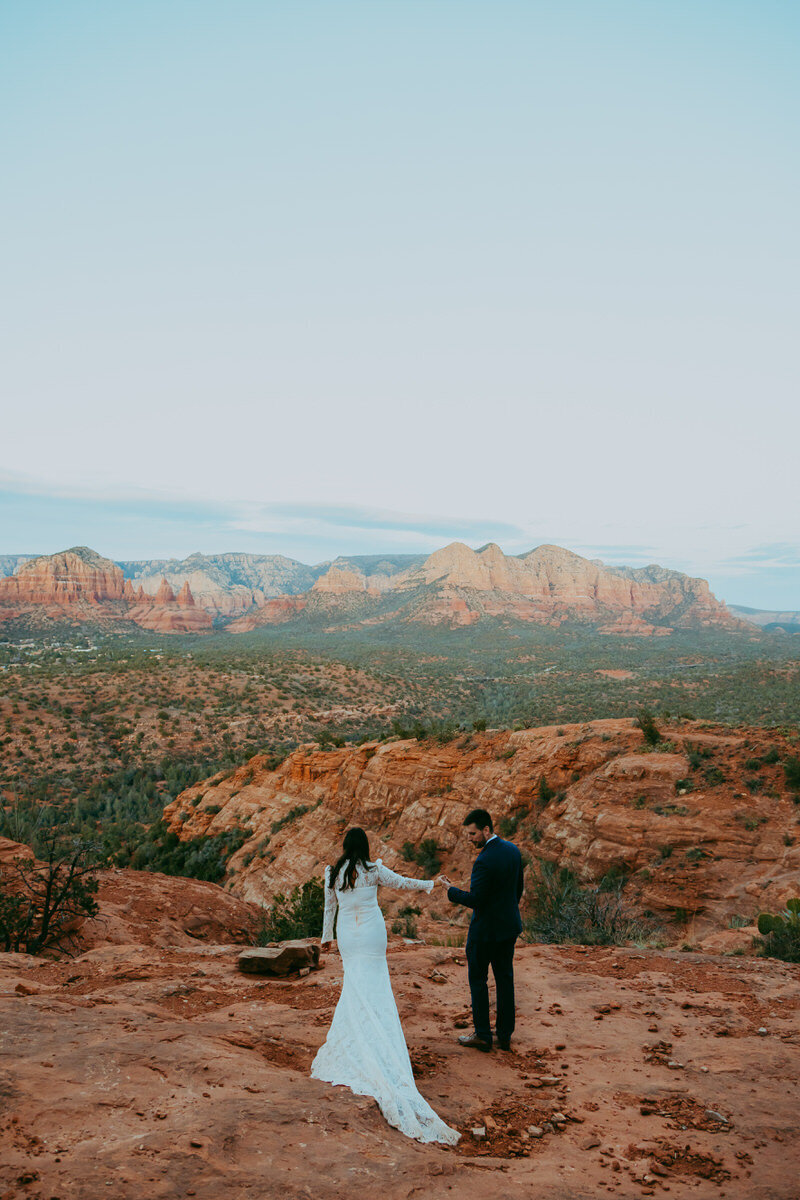 bride and groom walk in a sedona landscape