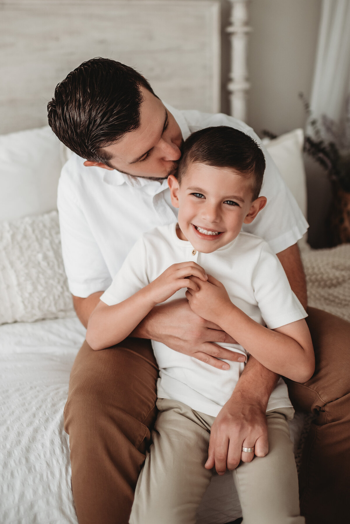 dad hugging son and kissing his head