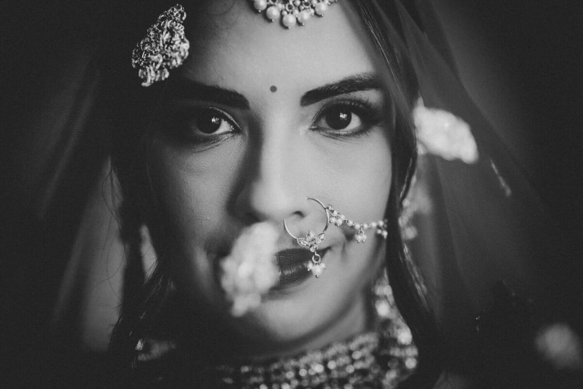 Black and white photograph of an Indian Bride under her veil during portraits.