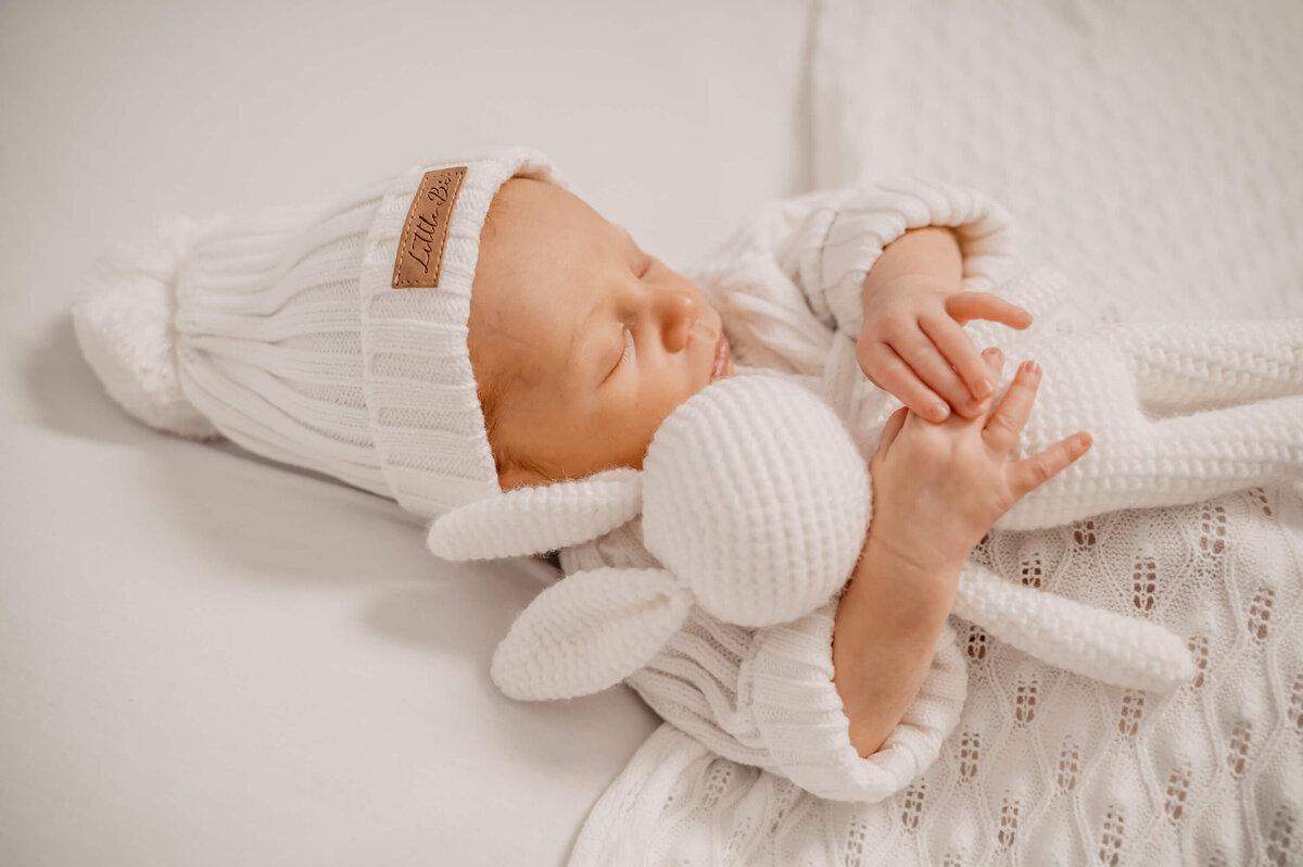 newborn baby holding white wrapped and sleeping under blanket - Townsville Newborn Photography by Jamie Simmons