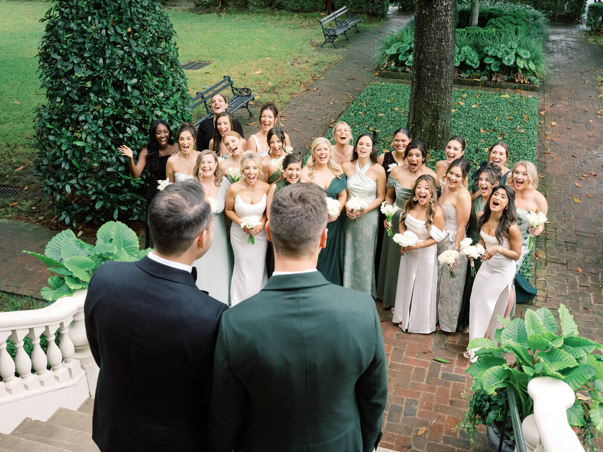 A joyful wedding party celebrating in a lush garden, capturing the happiness and excitement shared by friends while showcasing beautiful floral arrangements and outdoor elegance.