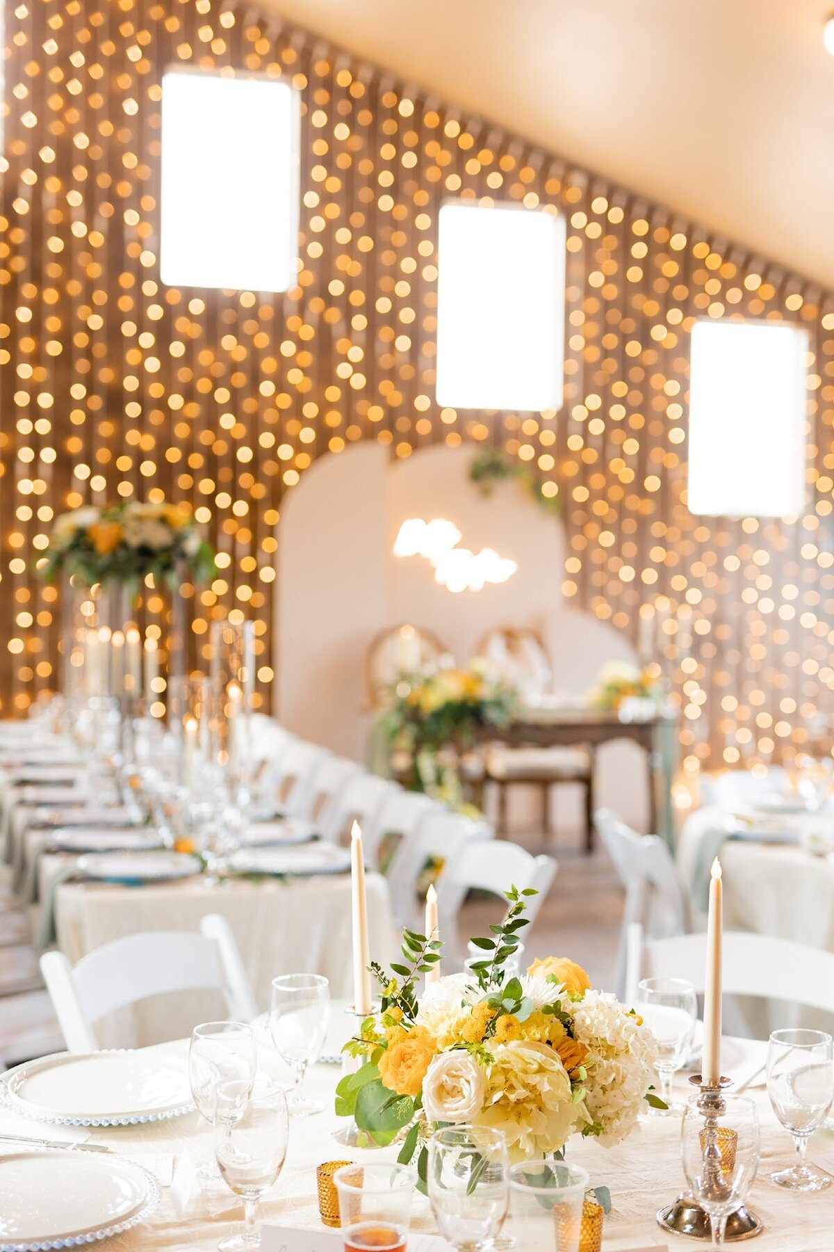green and yellow wedding reception with wall of string lights