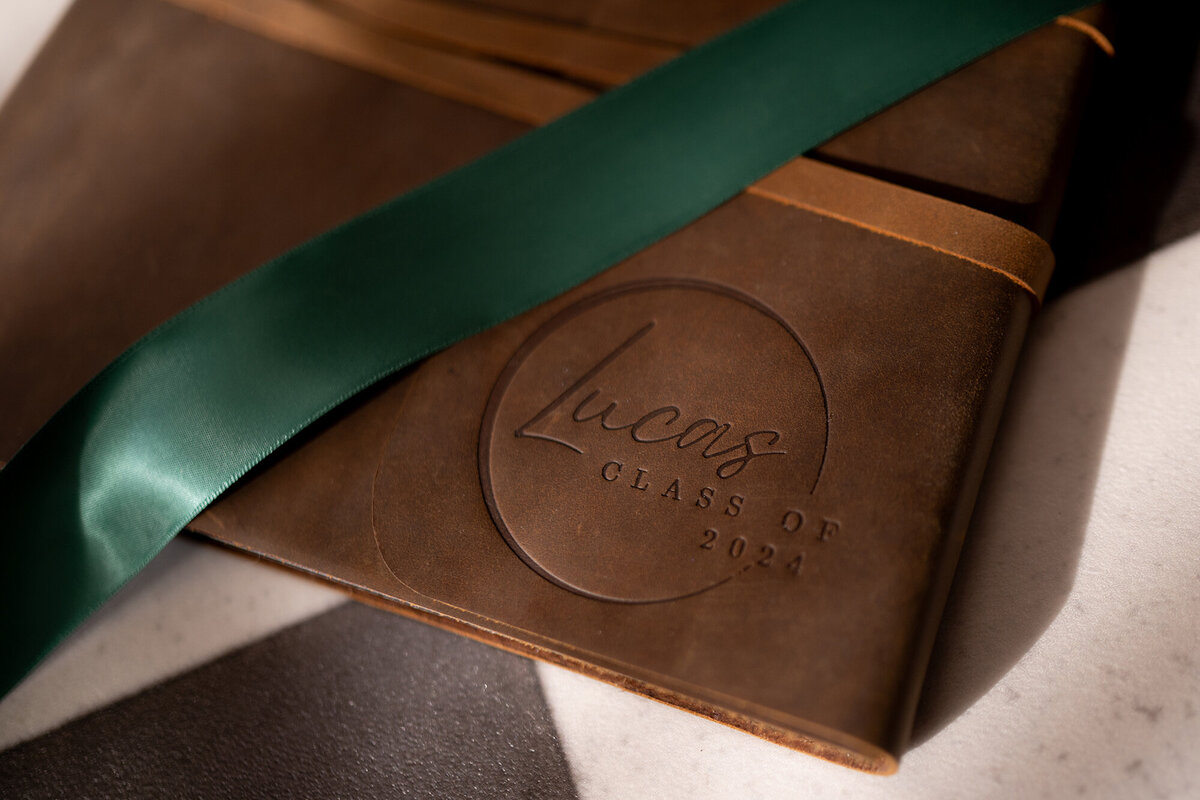 A green ribbon rest on top of a genuine leather album