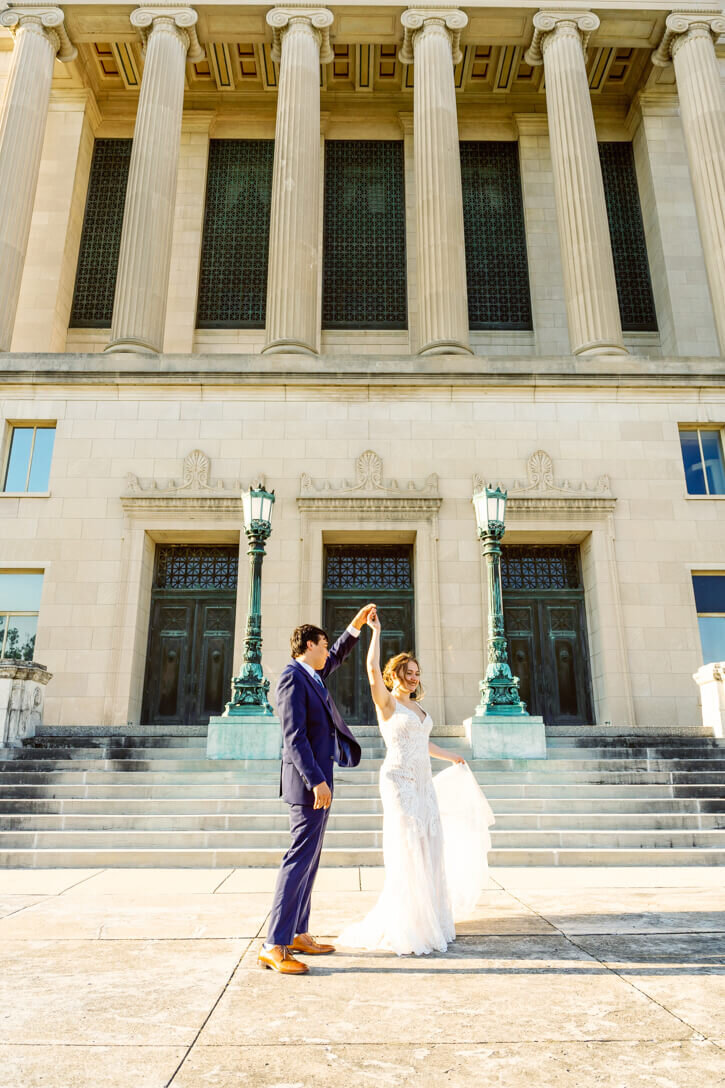 Bride and Groom dancing in front of their venue on their wedding day.