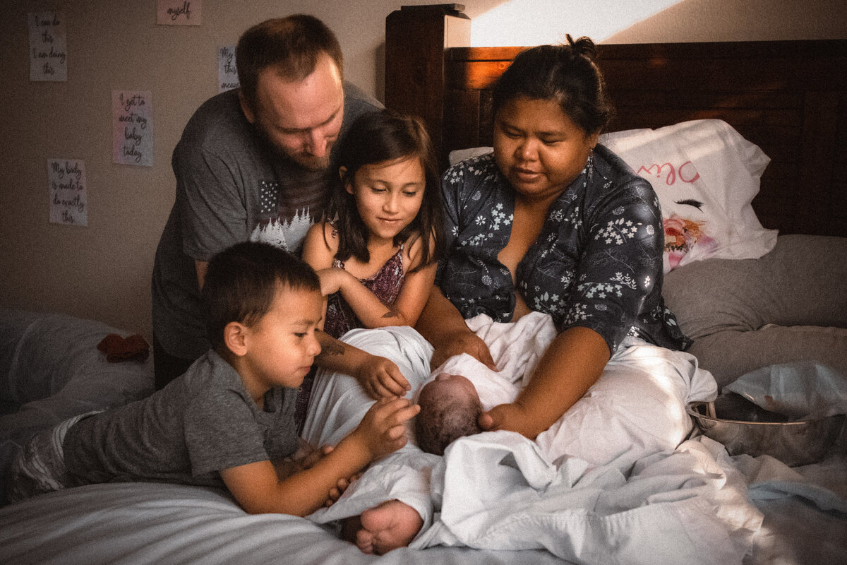 Homebirth family gazing at newborn baby