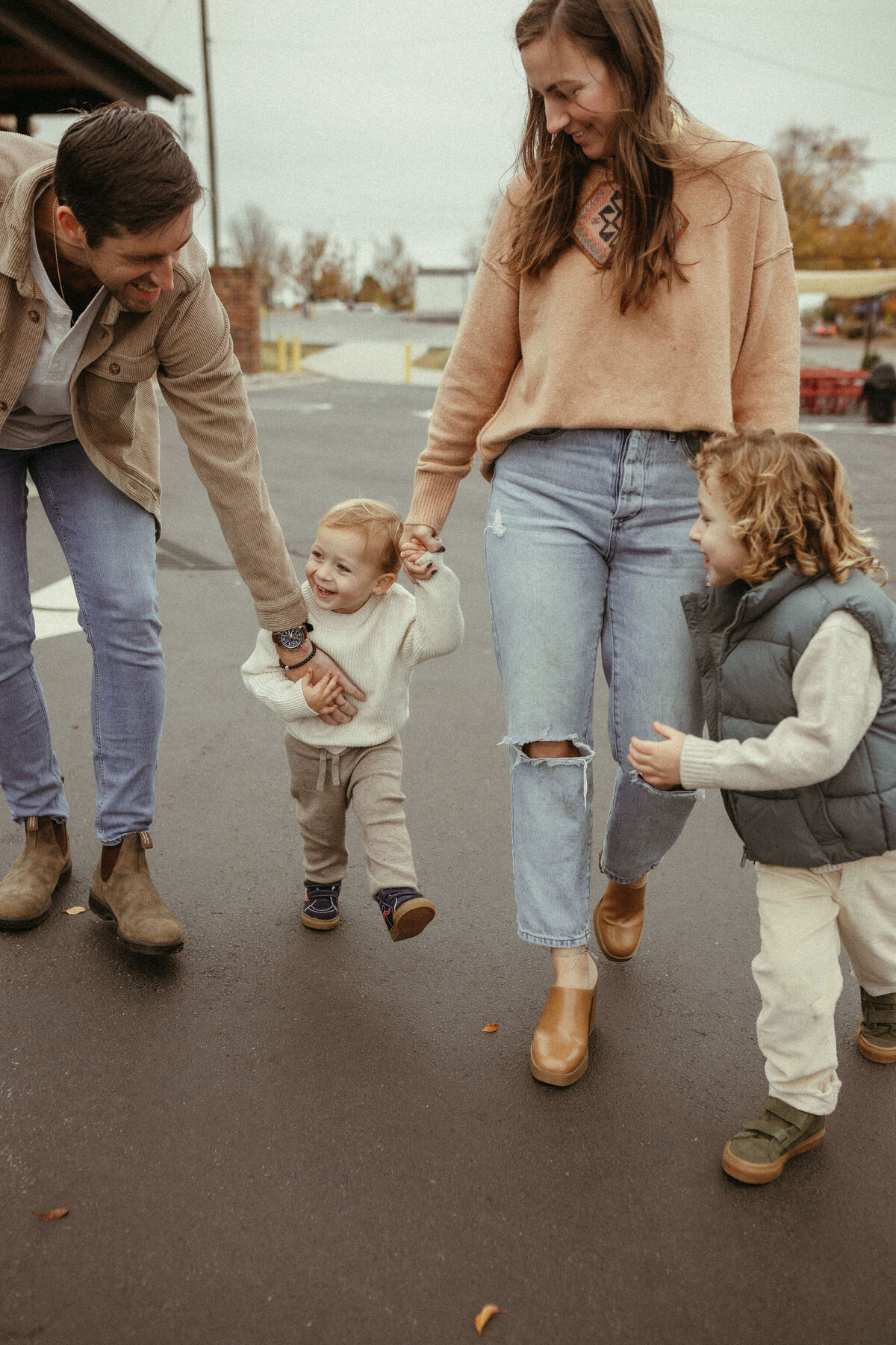 A mom and dad walking with their two happy toddler boys in downtown Marietta. 