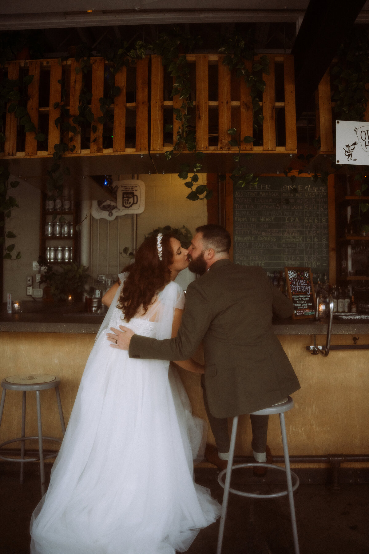 bride and groom kissing at bar