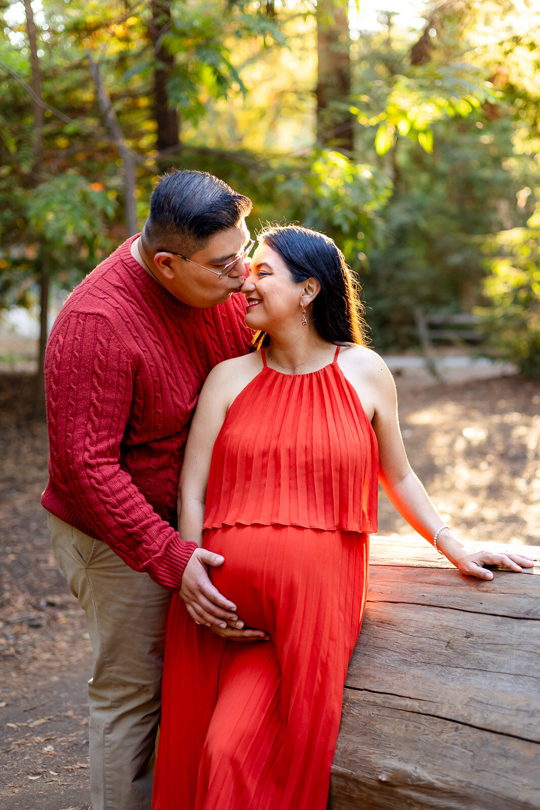 Pregnant couple kissing with the husband holding the baby bump in sunset light – Ellobelle Photography