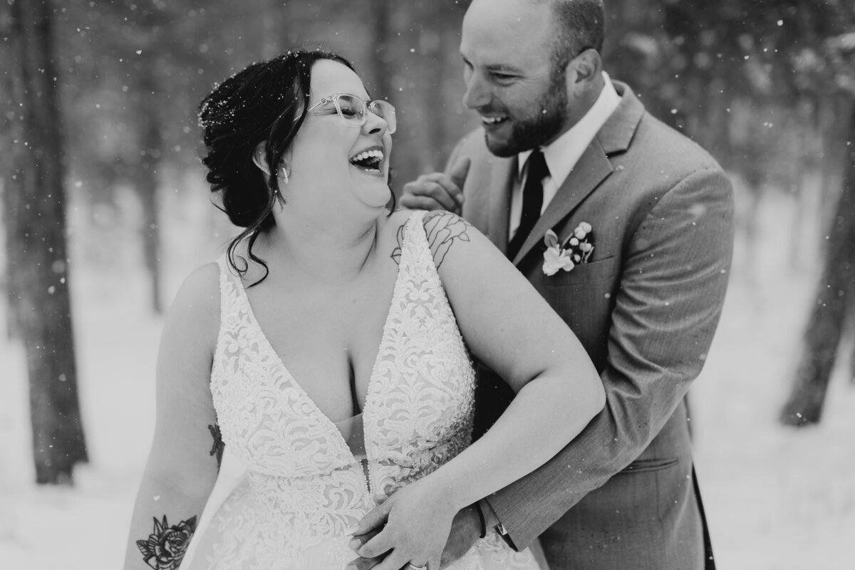 bride and groom laughing in the snow