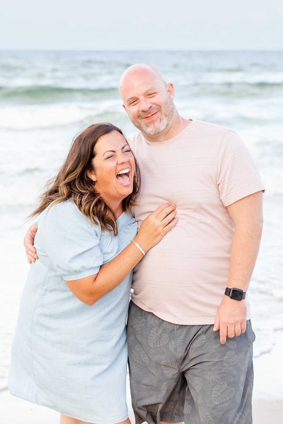 Wife laughing at husband at the beach