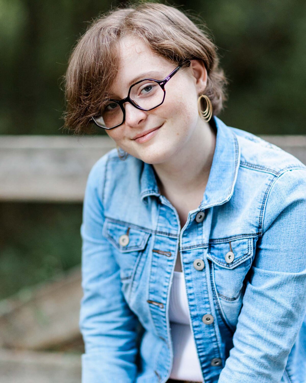Trendy headshot for an actor in a blue denim jacket with cool octagon shaped glasses.