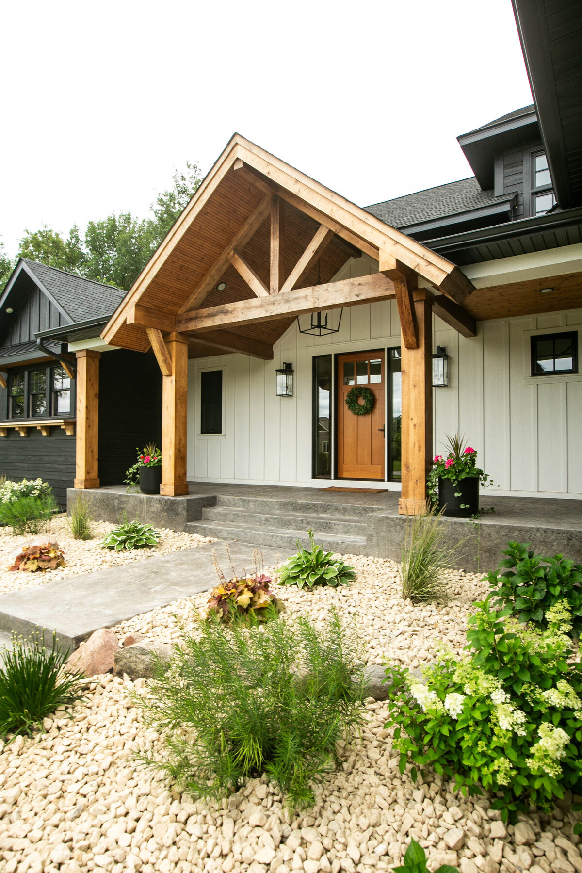Exterior view of custom home in Otsego, Minnesota with modern wood details and front porch built by Cornerstone Custom Builds