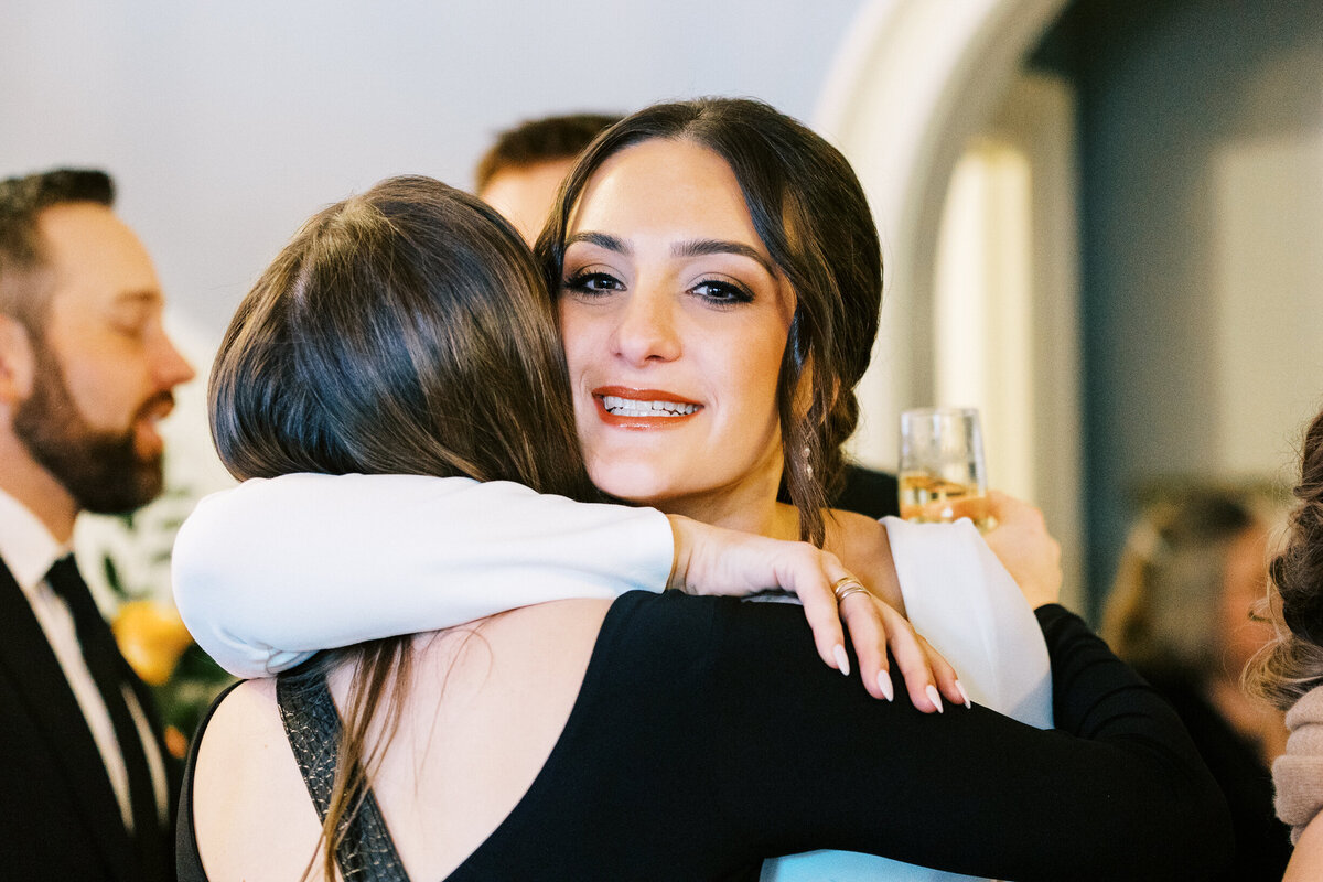 Bride getting a congratulations hug after the ceremony from her maid of honor.