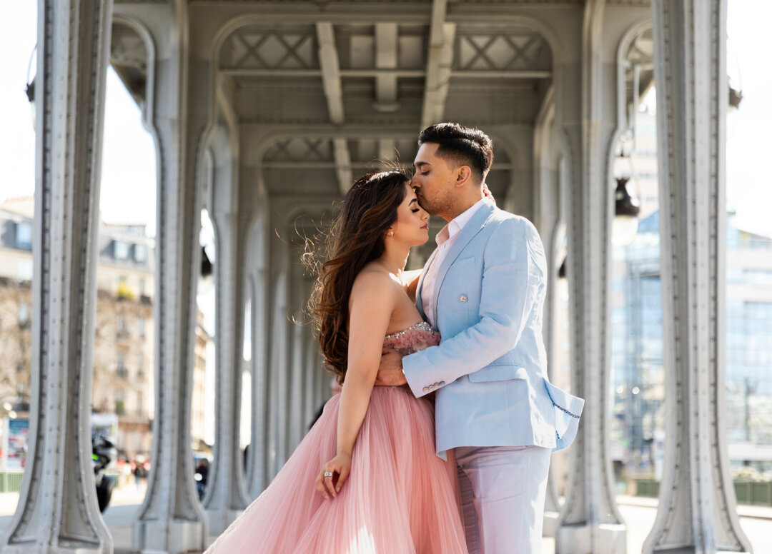 Intimate couple moment Bir Hakeim Bridge Paris, forehead kiss, romantic photoshoot, Eiffel Tower view